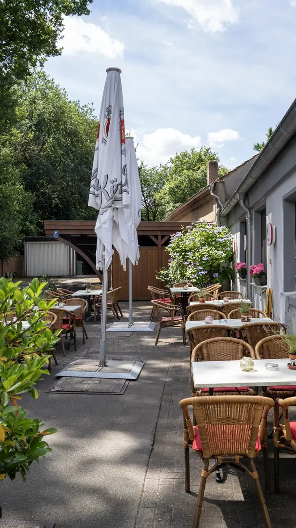 Biergarten Haus Breuing mit Korbstühlen und Hortensien